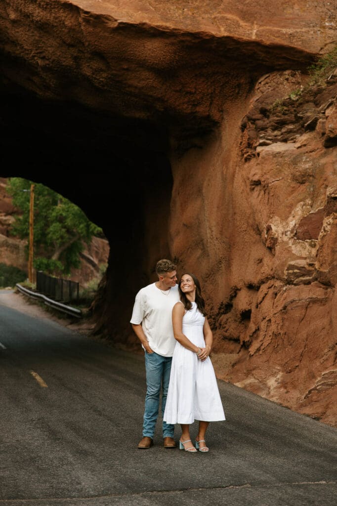 Jordan and Andrew standing together on a road surrounded by the red rock formations at Red Rocks